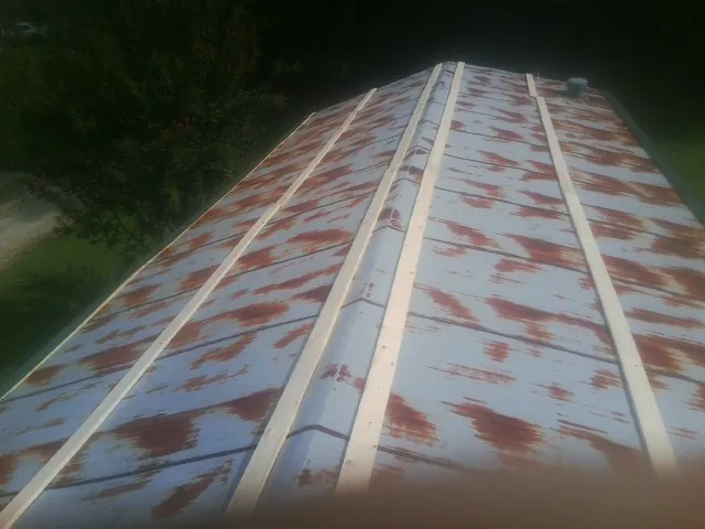 Rusted metal roof panels with new wood purlins before replacement — Storm Damage Roof Repair in Thomson by Roofing Brothers